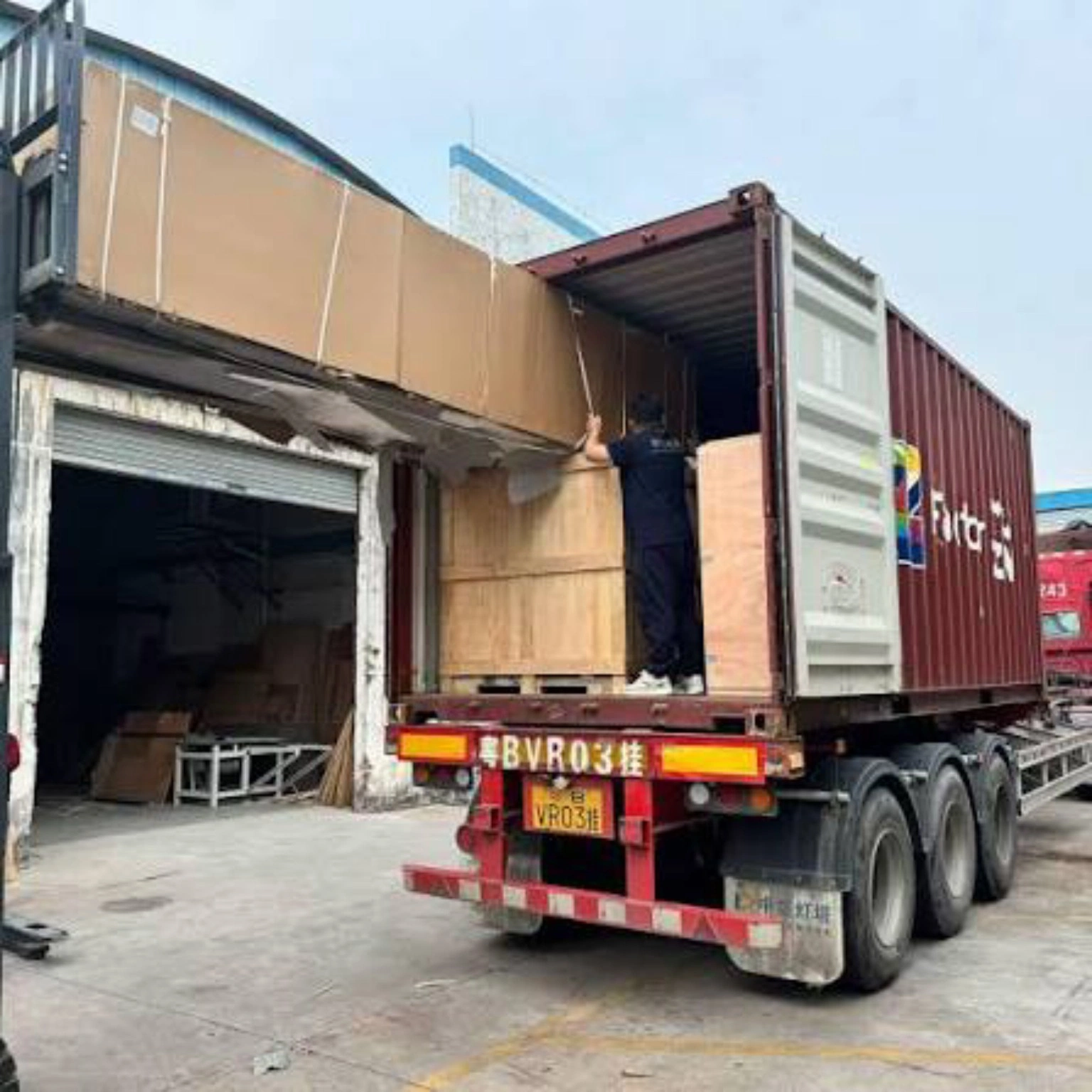 Careful container loading for export cargo Wooden export crates being loaded into a shipping container
