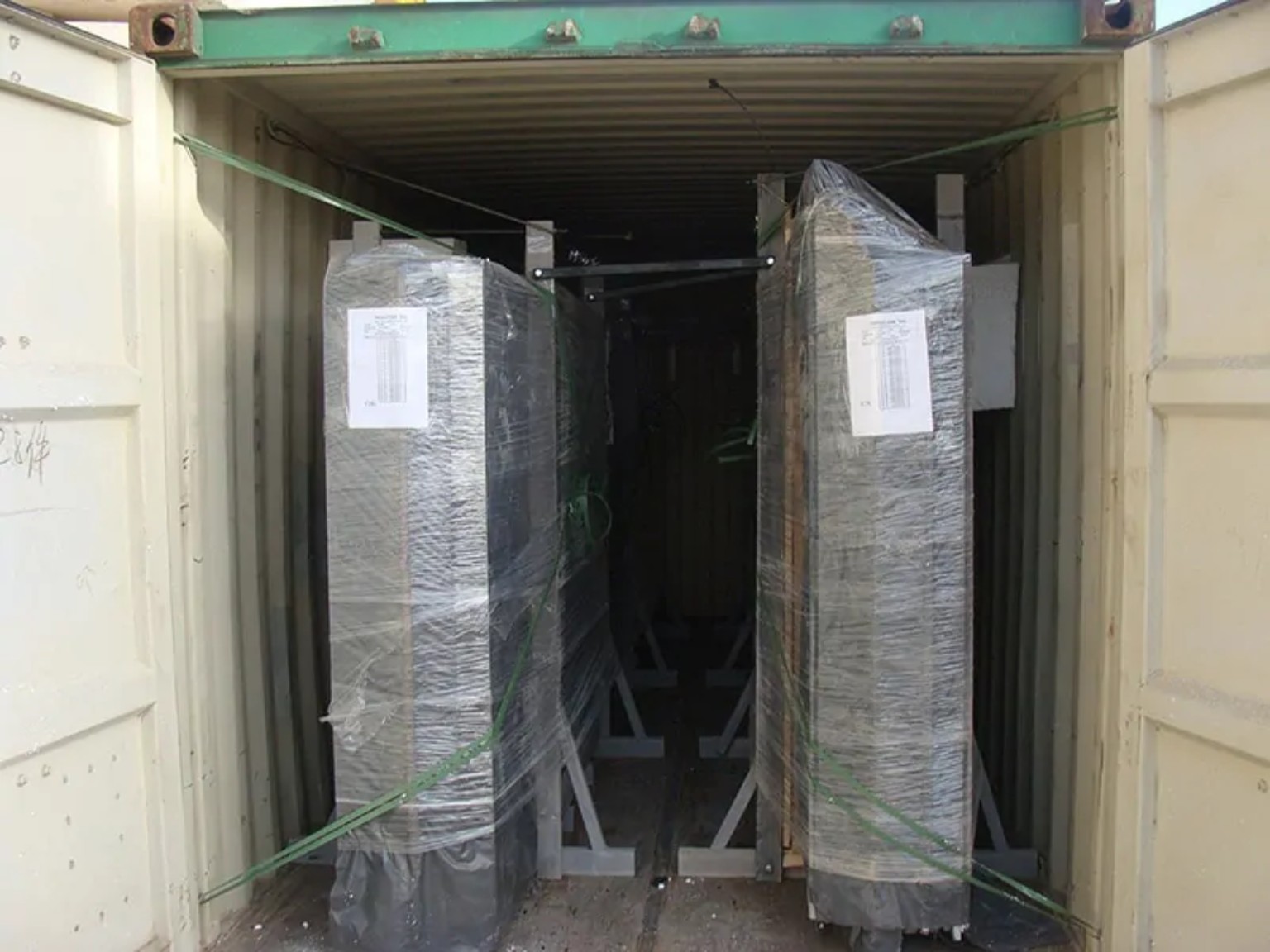 Protective packing for machinery inside export container Industrial machinery wrapped and secured inside a shipping container